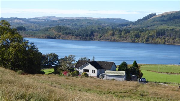 holiday cottage in the countryside with fields and a scottish loch